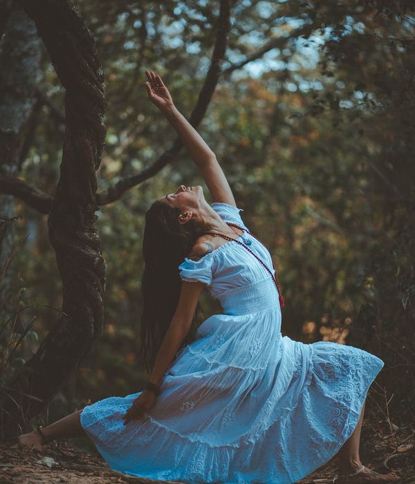 Woman in a graceful and balanced yoga pose outdoors.